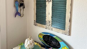Une pièce avec un volet décoratif, un panneau d’accueil, une décoration représentant un squelette et un panneau en forme de toile d’araignée.