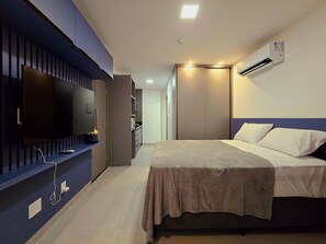 A hotel room with a bed, a television, a wardrobe, and an air conditioning unit. - Simple by Hosppedar (João Pessoa)
