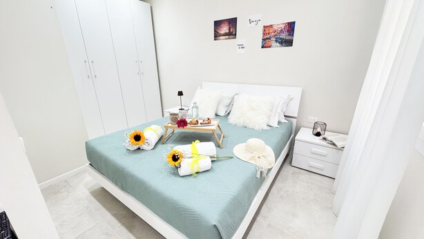 Ein ordentlich eingerichtetes Schlafzimmer mit Bett, Nachttisch und Kleiderschrank.