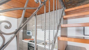 A modern kitchen with a wooden staircase and a metal railing. - Domus 4 in Como by Rent All Como (Como)