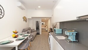 Une cuisine moderne avec un coin repas, un canapé et une vue sur le salon.