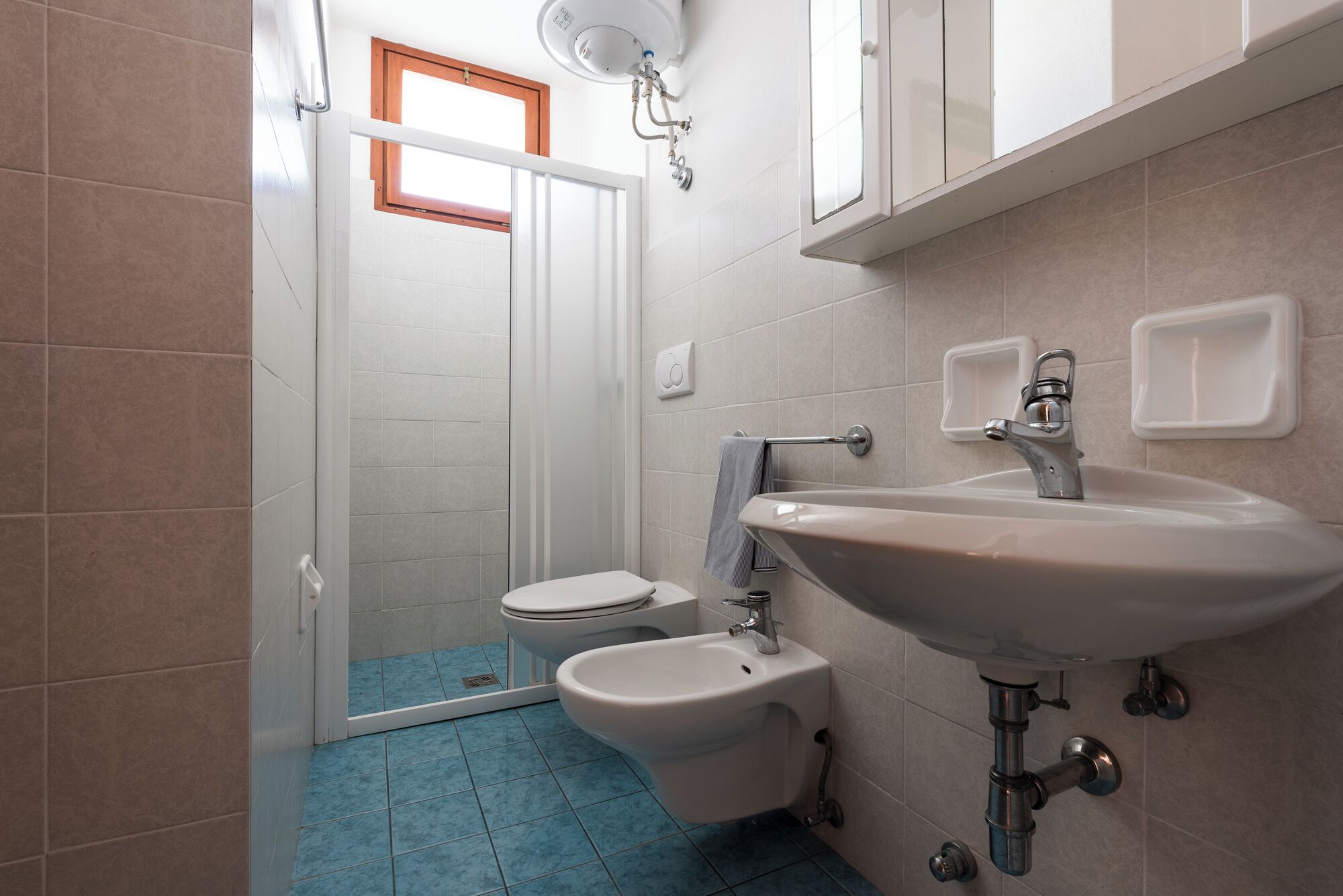A bathroom with a toilet, bidet, and sink.