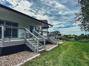 A modern two-story house with a covered porch and a staircase leading to the upper level.