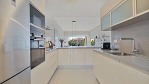 Una cocina moderna con electrodomésticos de acero inoxidable, una isla central y vistas a la ciudad.