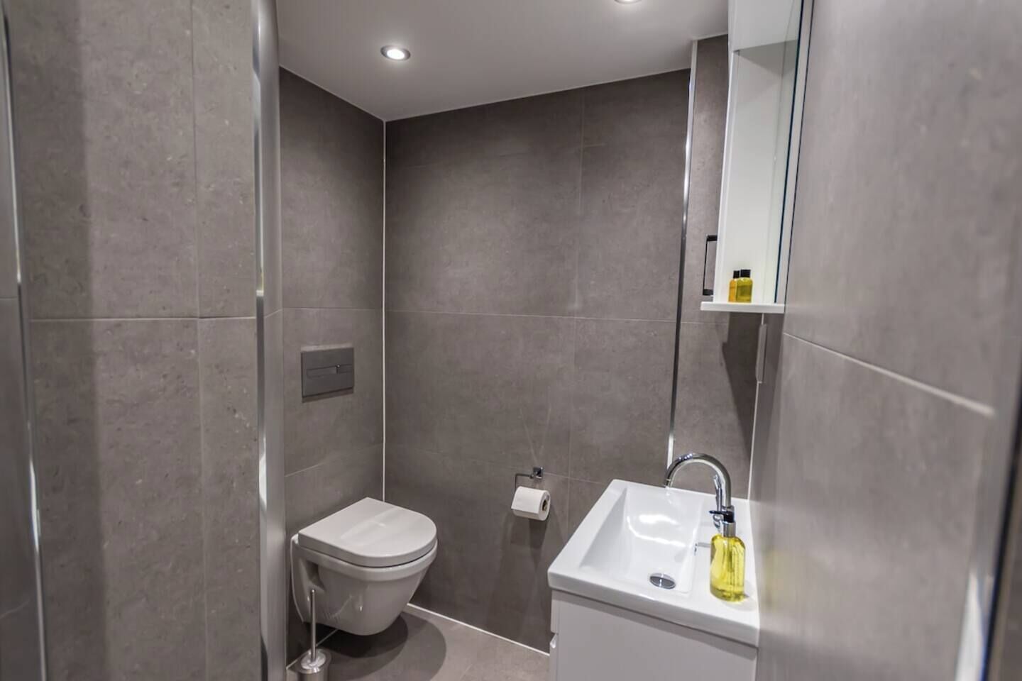 Une salle de bain moderne avec des toilettes, un lavabo et un miroir.