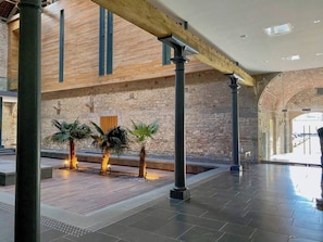 Un atrium intérieur doté d’un haut plafond, de murs en pierre et d’un plancher en bois.