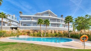 A modern multi-story hotel with a swimming pool, palm trees, and a lifebuoy. - Stylish apartment with oceanview (Málaga)