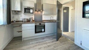A modern kitchen with built-in appliances, a microwave, oven, and a stainless steel range hood.