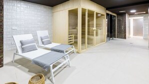 Une salle de spa avec deux lits blancs, un meuble en bois et un sol carrelé.