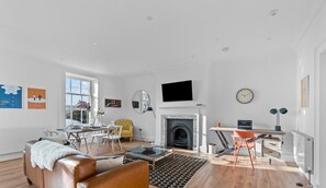 A modern living room with a fireplace, a dining area, and a workspace. - Luxury 2 bed apartment Mount Wise Plymouth parking (Plymouth)