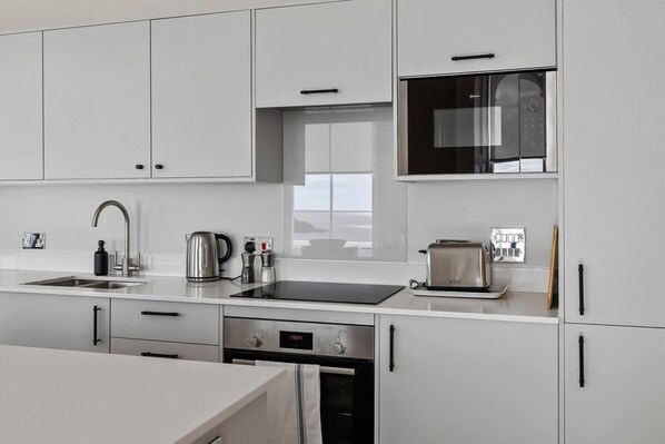 A modern kitchen with stainless steel appliances, a built-in microwave, and a toaster.