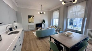 Une cuisine moderne avec un coin repas, un téléviseur et un radiateur.
