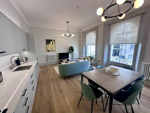 Une cuisine moderne avec un coin repas, un téléviseur et un radiateur.