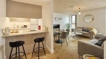 A modern apartment with a kitchen, dining area, and living room.