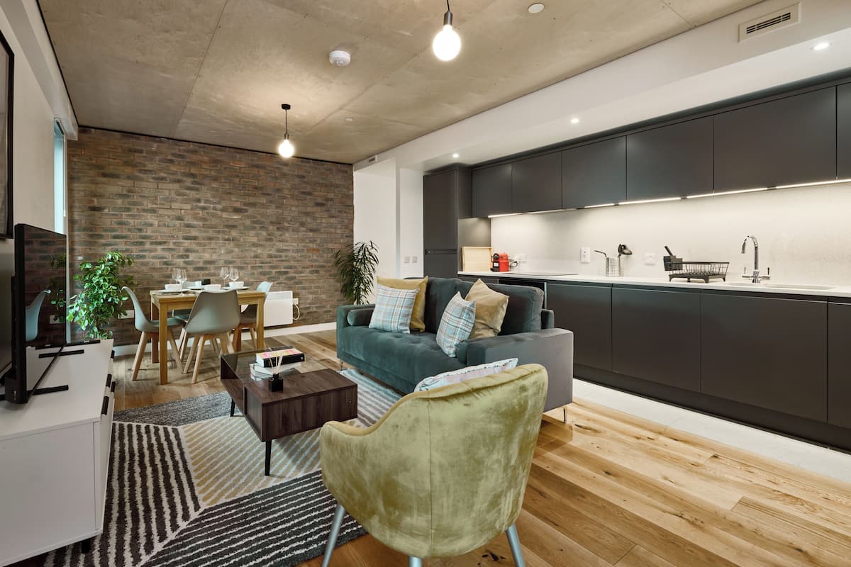 A modern living room with a dining area, a kitchen, and a large window.