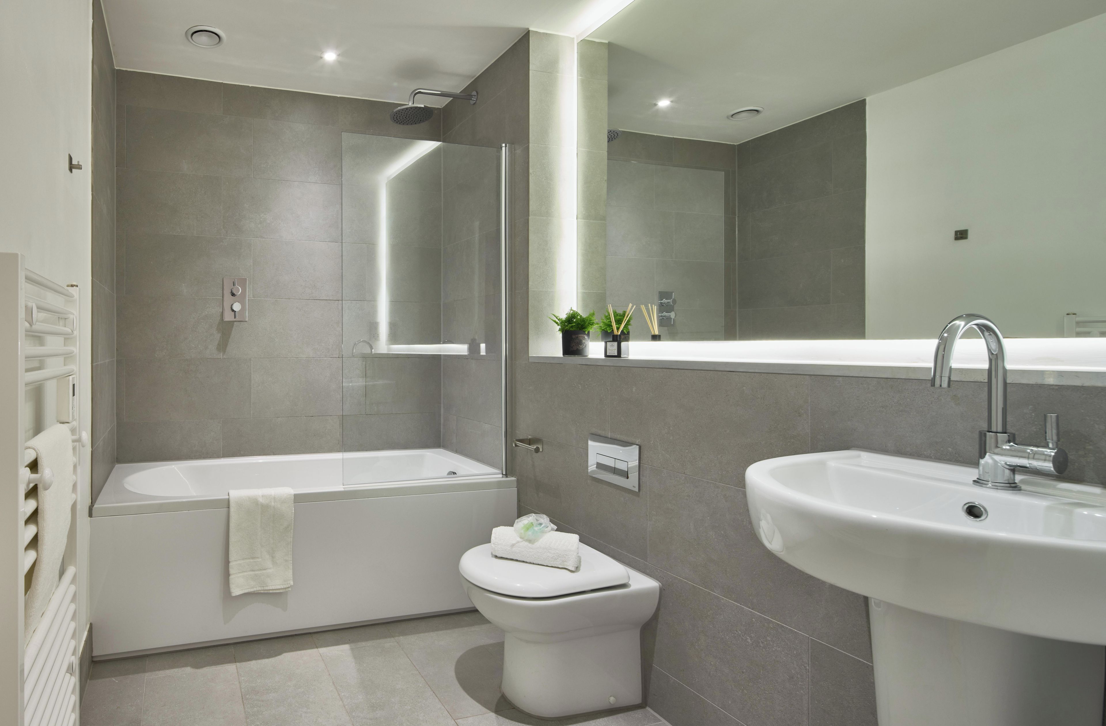 A modern bathroom with a bathtub, toilet, and sink.
