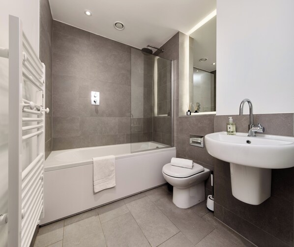 Un bagno moderno con vasca, water e lavandino.