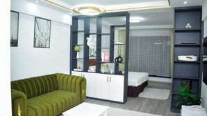 Una sala de estar moderna con un sofá verde, una mesa de centro blanca y un armario empotrado con estantes.