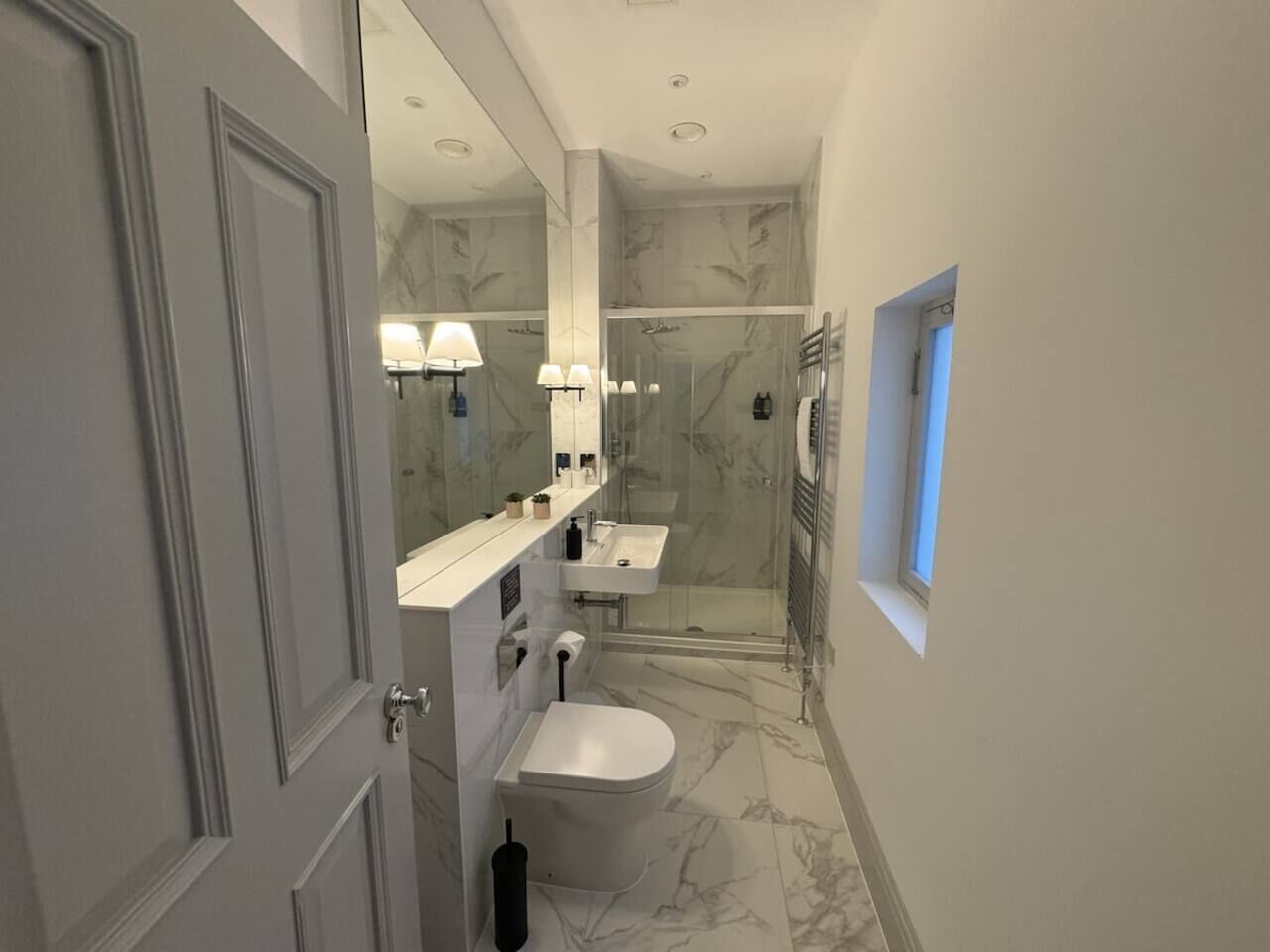 Ein Badezimmer mit Toilette, Waschbecken und Duschbereich.