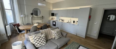 Un salon moderne comprenant un canapé, une table basse et un coin repas avec des chaises et une table.