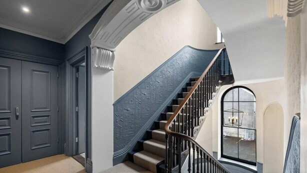 A staircase with a decorative handrail and a modern light fixture at the top. - Huge spacious 8 bed luxury villa (Plymouth)