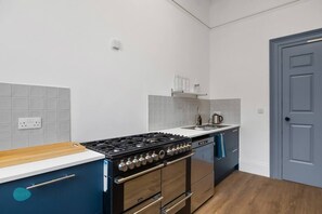 A modern kitchen with a gas stove, oven, and a sink.