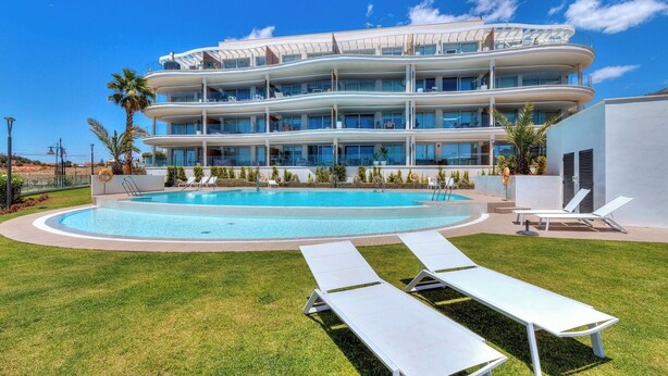 A modern hotel with a large pool, multiple balconies, and outdoor seating areas. - Modern 3bdr aprt - Ocean view (Fuengirola)
