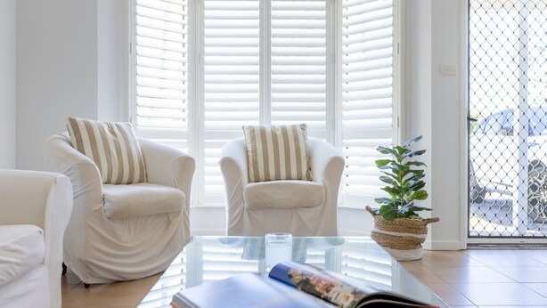 A modern living room with two white armchairs, a glass coffee table, and a potted plant. - Seatown - Spacious Townhouse Close to Pippi Beach & Yamba Shops - Holiday Yamba (Yamba)