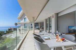 A balcony with a dining table set for two, overlooking a coastal view. - Amazing ocean view apartment - Higueron (Fuengirola)