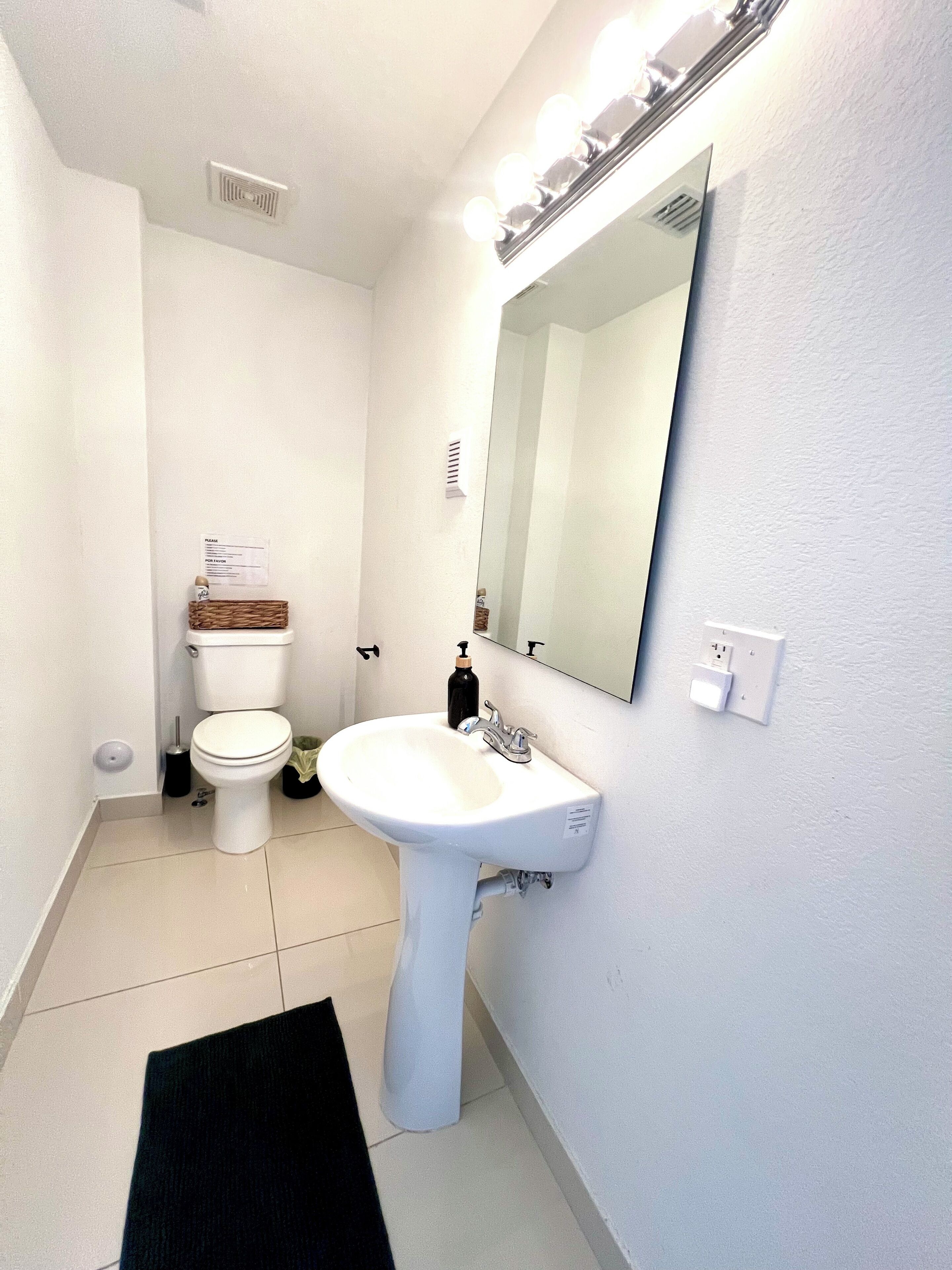 Une salle de bain avec des toilettes, un lavabo et un miroir.