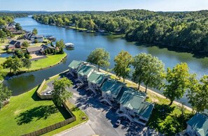 A lakeside property with multiple buildings, a dock, and a well-maintained lawn.