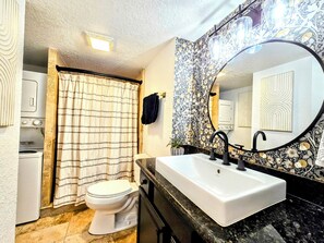 A bathroom with a toilet, a sink, and a shower curtain.