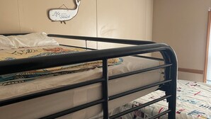Una cama litera con cabecera y un letrero decorativo.