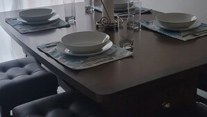 A dining area with a rectangular table set for four, surrounded by black cushioned chairs. - Charming 3-bedroom, 2 bath condo, fully furnished in marvelous St. Simons Island (St. Simons Island)