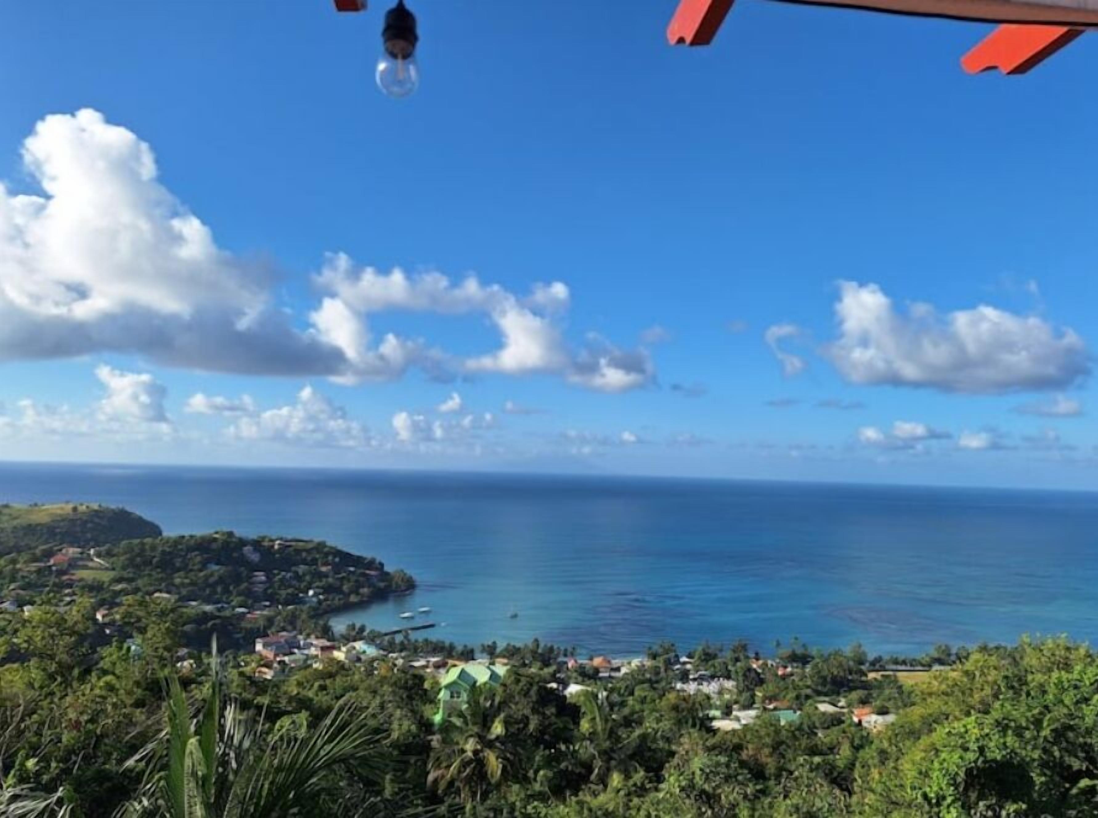 A coastal landscape with a clear sky, a view of the sea, and a town below.