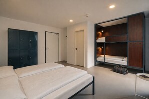 Une chambre à coucher comprenant un lit, une armoire et un banc intégré avec espace de rangement.