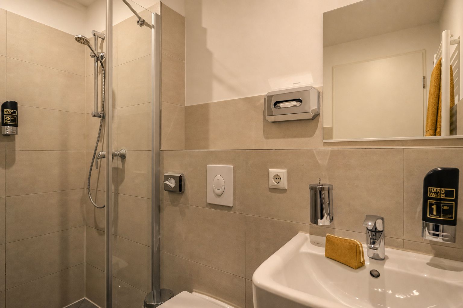 A modern bathroom with a shower, toilet, and sink.