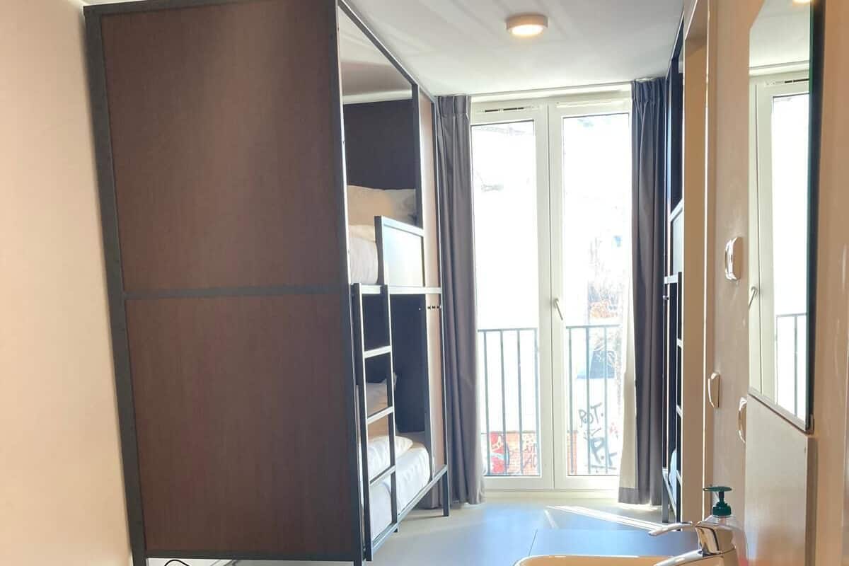 A modern bathroom with a large sink, a mirror, and a view of a balcony.