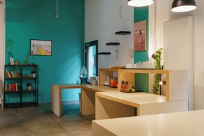 Un intérieur moderne avec des murs de couleur turquoise, un bureau en bois et une bibliothèque.