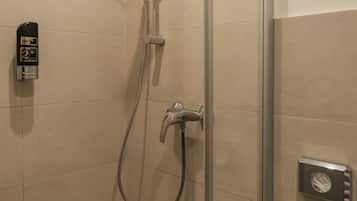 Una ducha con cabezal de ducha de mano, grifo empotrado y manguera de ducha.