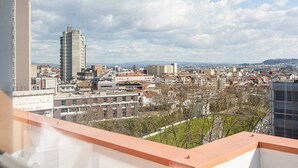 Un paisaje urbano con una mezcla de edificios modernos y antiguos, un rascacielos destacado y un cielo despejado.