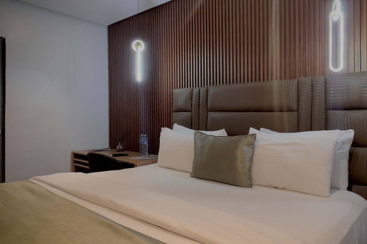 Departamento exclusivo, 1 cama King size y sofá cama, vista a la ciudad | Área de sala de estar | Televisión de 43 pulgadas con canales por cable