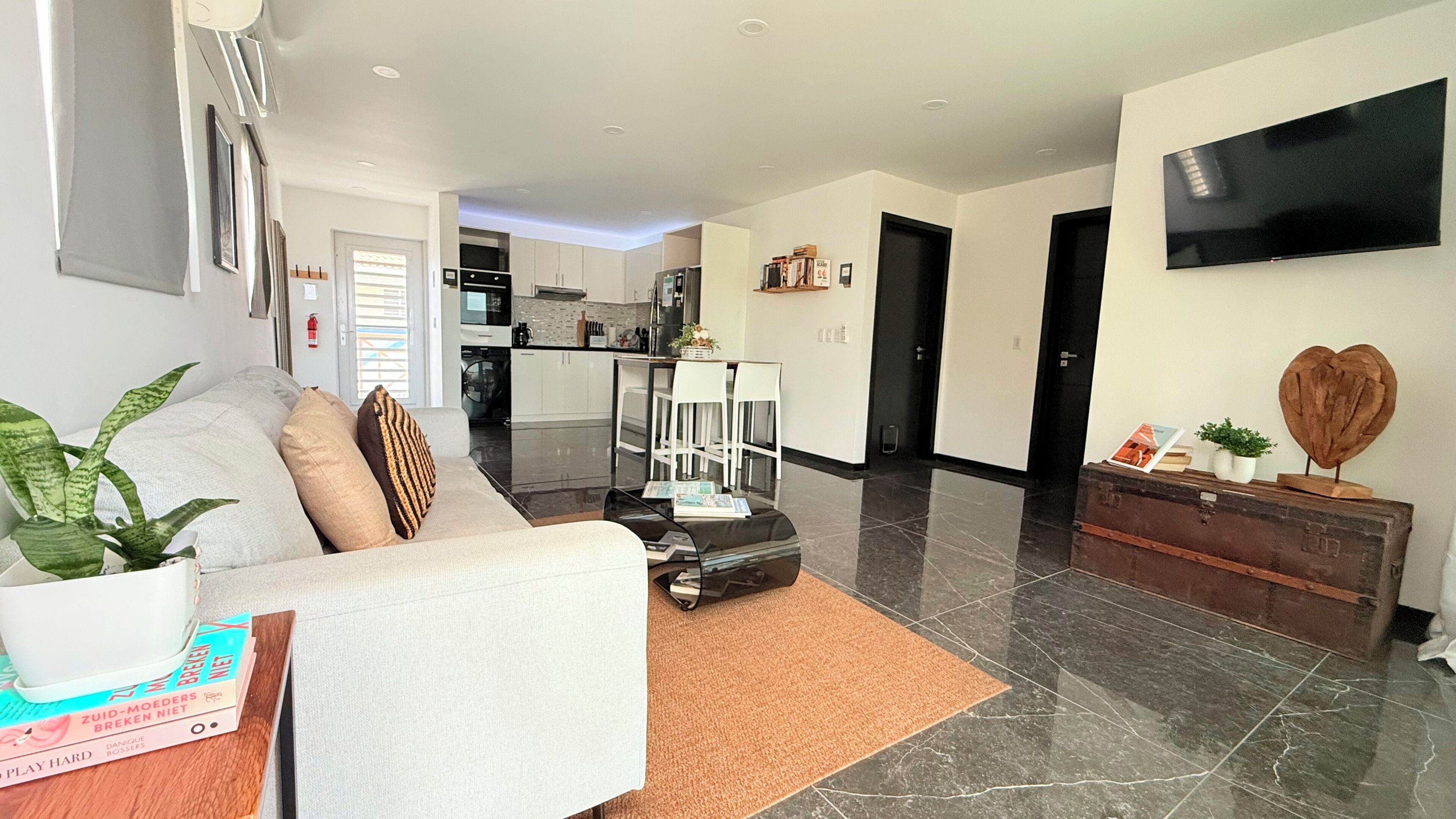 A modern living room with a sofa, coffee table, and a flat-screen TV.