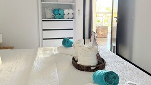 Un dormitorio con cama, armario y vista por una puerta abierta.