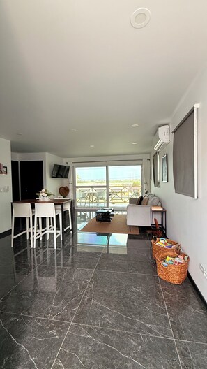 A modern kitchen with a dining area, large windows, and a view of the outdoors. - ✨ Kas Pitava - Cozy 2BR Apartment with Pool & Terrace Near Town (Kralendijk)