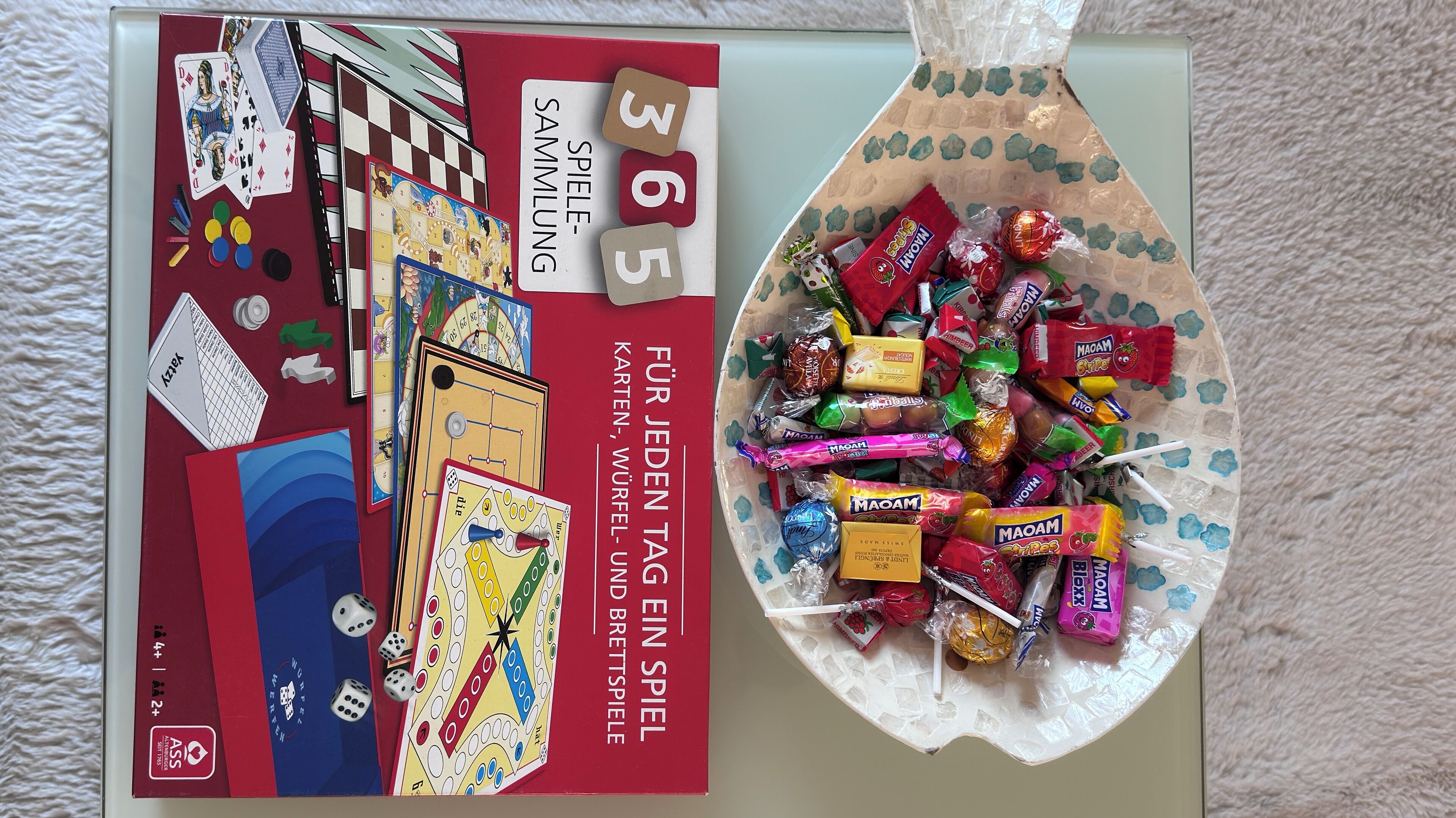 A board game box and a basket of assorted candies.