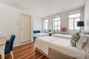 Habitación de hotel con dos camas, un escritorio, una silla y un televisor.