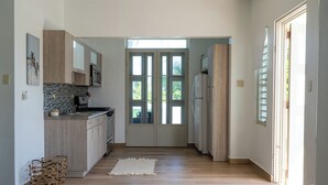 Una cocina moderna con armarios de madera, un microondas y un ventanal grande.