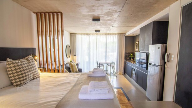 Une chambre d’hôtel avec un lit, une petite kitchenette et une vue sur l’extérieur.