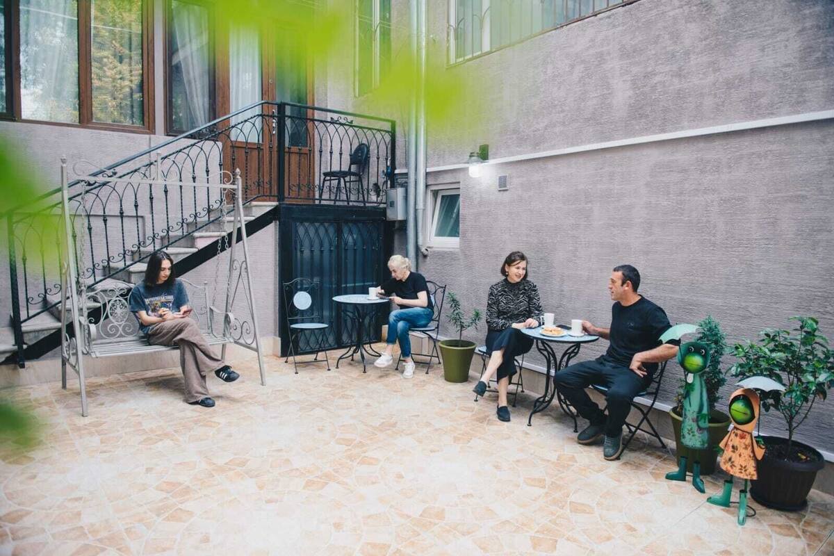 A courtyard with a staircase, outdoor seating, and potted plants.
